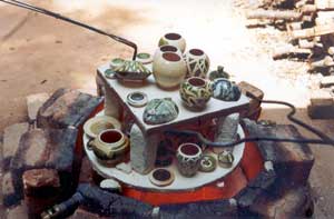 The ware transferred with tongs into a saggar with combustible materials or on a pile of sawdust to 'reduce'.