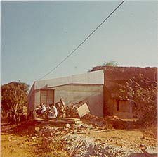 Pour Tous employees, Ellumalai and Krishna, waiting for the bullock cart to pull up and unload at the door of the first Pour Tous building, Aspiration, 1974.