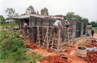 Masons completing the walls for new storerooms on the back of the godown