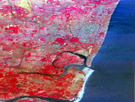 Satellite photo showing the pier and the enlarged beach (white, below right) south of the new breakwater. Pondicherry town with its characteristic oval grid pattern is north