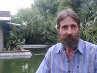 Herbert next to his rainwater catchment tank